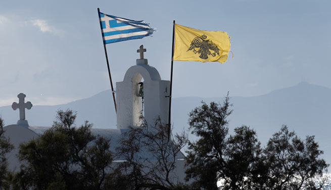 Греческий и византийский флаги над часовней в городе Наксос. 