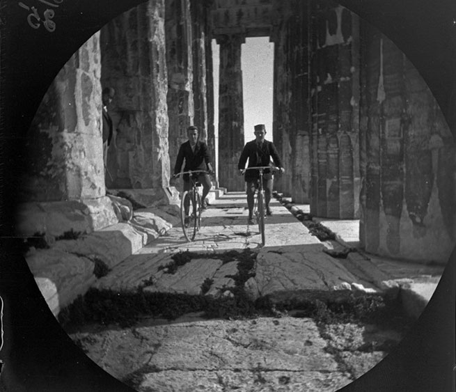 Уильям и Том на велосипедах у колоннады Парфенона.
