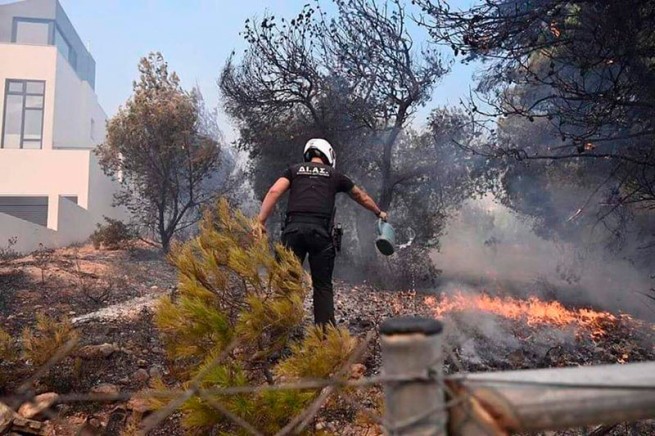 Mit Gießkannen und Gartenschläuchen hat die Polizei einen Brand in Athen bekämpft