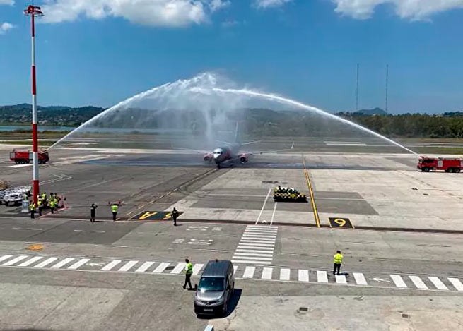 Первый рейс из Великобритании был торжественно принят в аэропорту Корфу . Самолет встретили водной аркой.