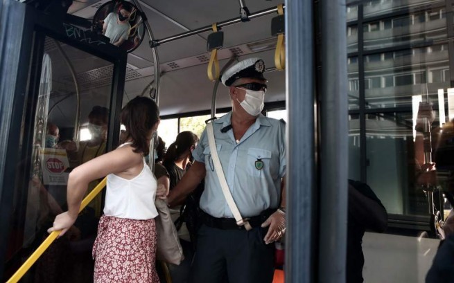 Полицейский осматривает автобус на предмет нарушений правил техники безопасности в Афинах. [InTime News]