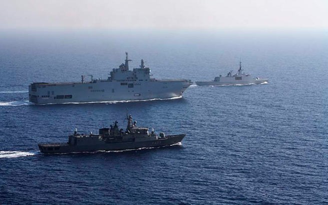 Французский вертолетоносец Tonnerre (сзади слева) сопровождается греческими и французскими военными кораблями во время морских учений в Восточном Средиземноморье. [AP]