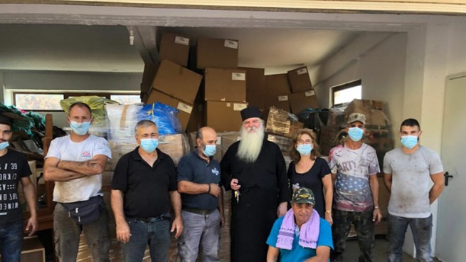 Отец Никодимос, д-р Ольга Сарантопулу и местные волонтеры, которые помогают разгружать и распределять гуманитарную помощь из Австрии