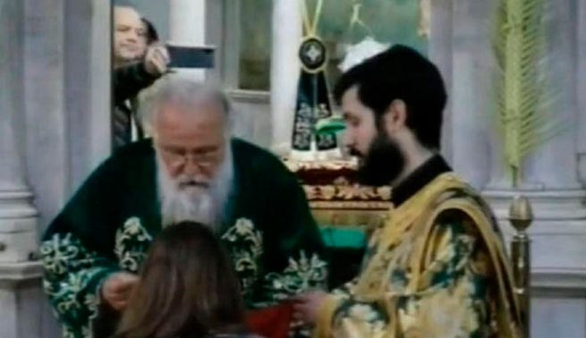 Митрополит Нектарий дает прихожанам  Святое Причастие на Вербное воскресенье (12 апреля 2020)  в храме Святого Спиридона на Керкире.