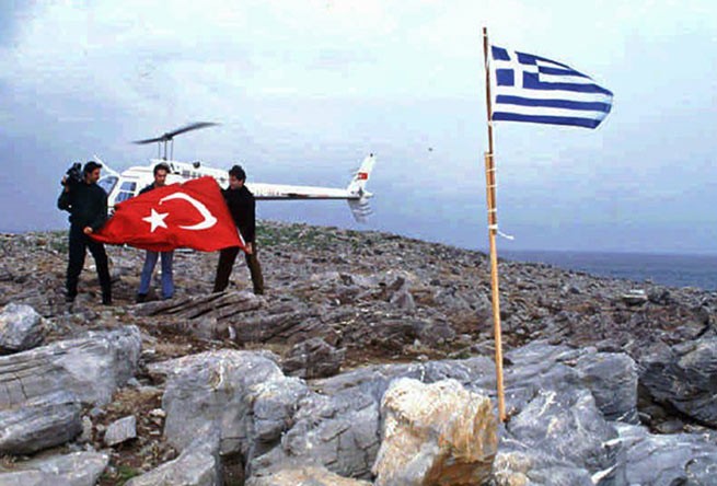 Турецкие журналисты поднимают турецкий флаг на острове Имиа. Фото: Aykut Firat / Hurriyet / AP