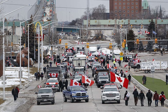 Протестующие и сторонники устроили блокаду у подножия Амбассадорского моста, перекрыв поток коммерческого транспорта по мосту в Канаду из Детройта, 10 февраля 2022 года, в Виндзоре, Канада.